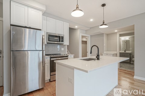 A modern kitchen with a stainless steel refrigerator and white countertops.