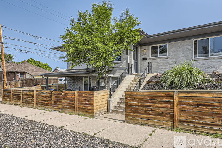 A house with a wooden fence in front of it is for sale.