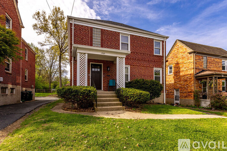 A red brick house with a white door and windows.