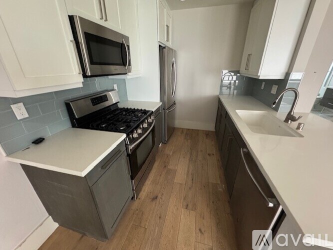 A kitchen with a stove top oven and a refrigerator.