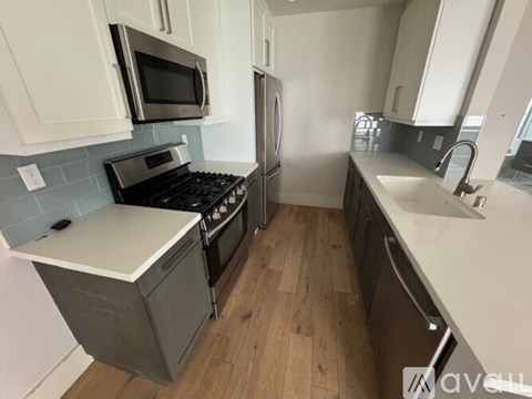 A kitchen with a stove top oven and a refrigerator.