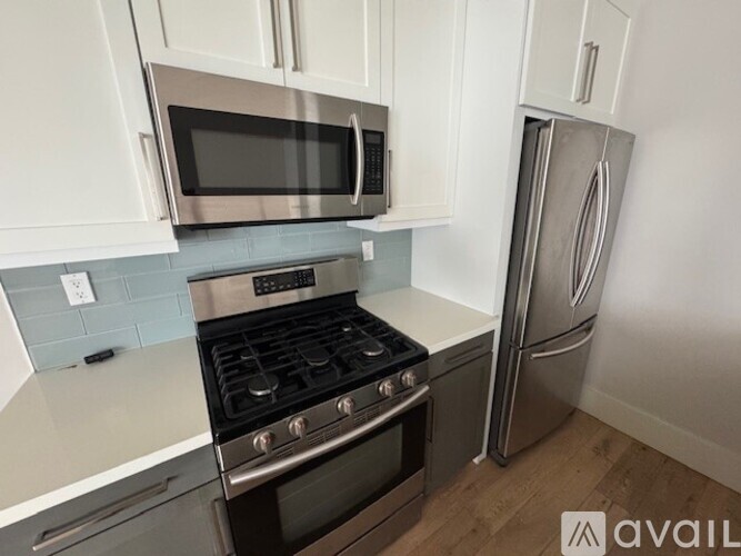 A kitchen with a stove, microwave, and refrigerator.