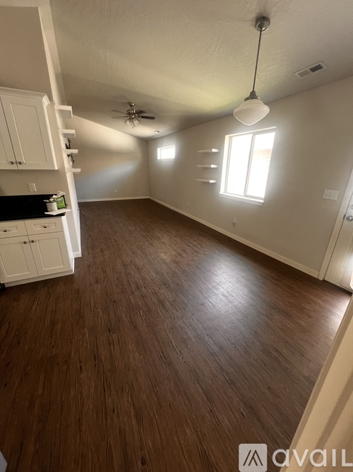 A room with wooden flooring and a window letting in natural light.