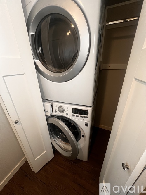 A washing machine is in a small space between two doors.