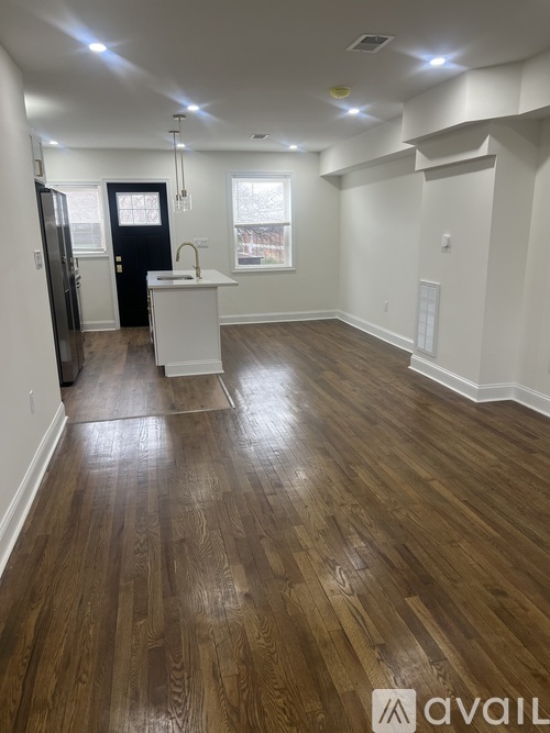 A room with wooden flooring and white walls.