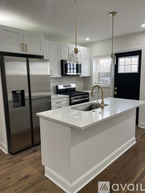 A modern kitchen with a white island and stainless steel appliances.