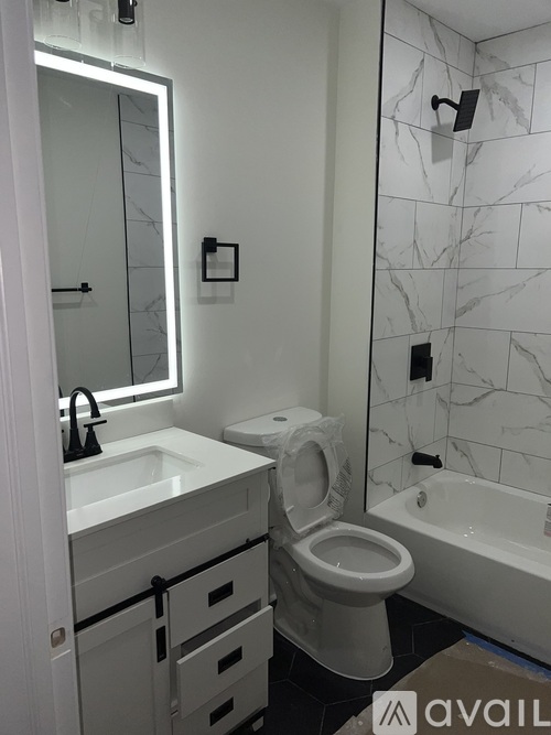 A white toilet in a bathroom with a marble wall.
