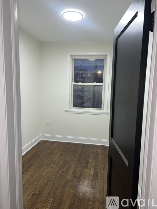 A room with a window and a wooden floor.