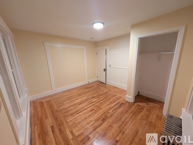 A room with wooden flooring and white walls.