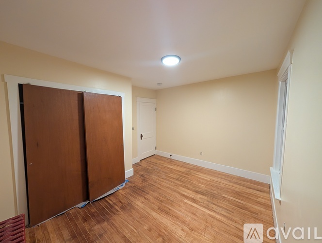 A room with a wooden floor and a white ceiling with a light fixture.