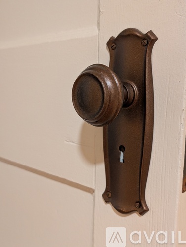 A brown door knob is on a white door.