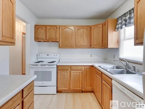 A kitchen with wooden cabinets and white appliances.