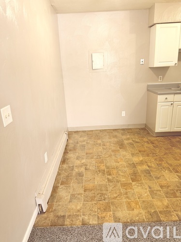 A kitchen area with a tile floor and a cabinet.
