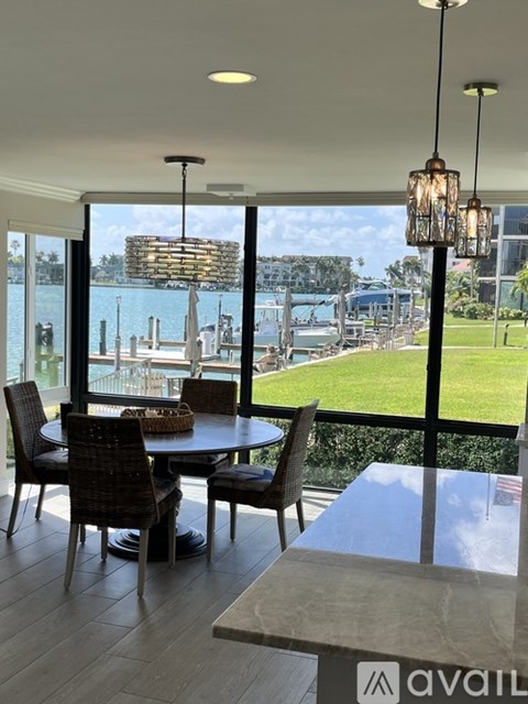 A dining room with a view of the water and a pool.