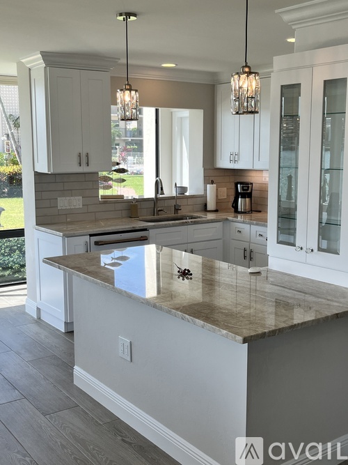 A kitchen with white cabinets and appliances.