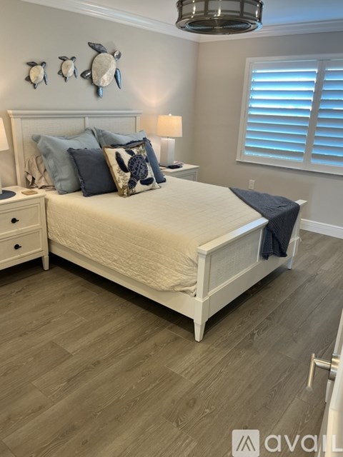 A bedroom with a bed, nightstand, and two turtle decorations on the wall.
