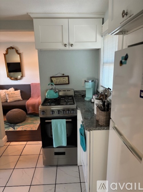 A kitchen with a white refrigerator and a stove top oven.