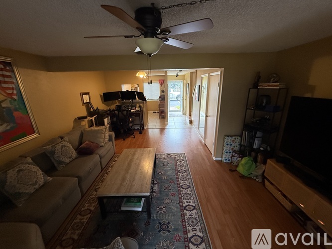 A living room with a couch, coffee table, and a ceiling fan.