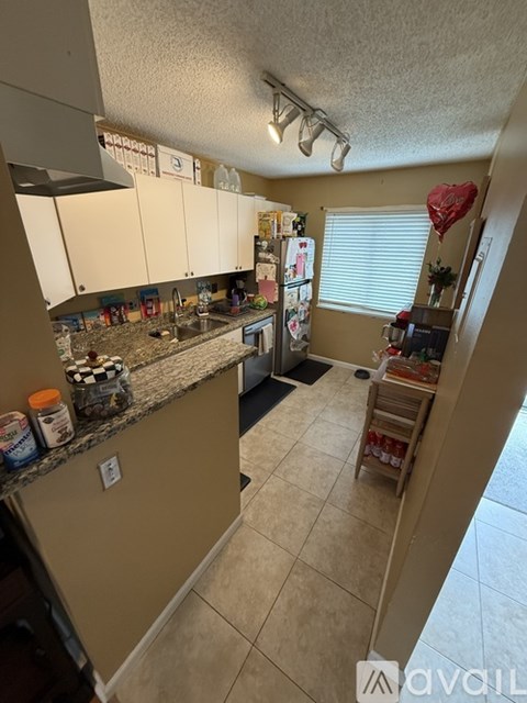A kitchen with beige cabinets and a countertop with various items on it.