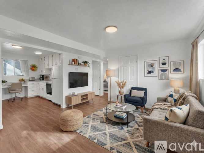 A living room with a couch, a chair, a coffee table, and a television.