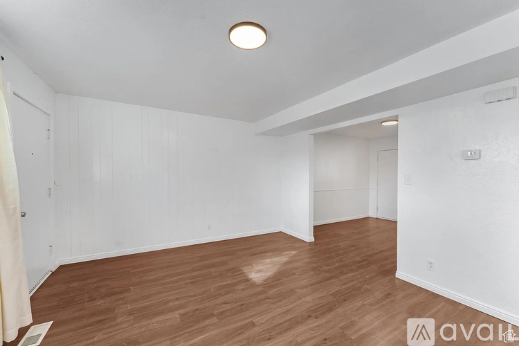 A room with wooden flooring and white walls.