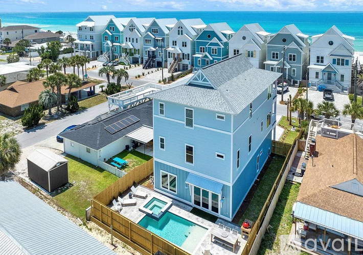 A blue house with a pool in front of it.
