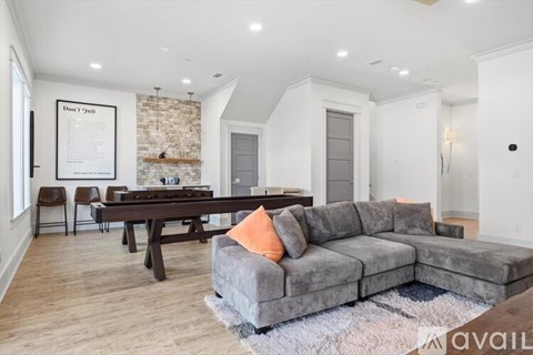 A living room with a grey couch and a wooden table.