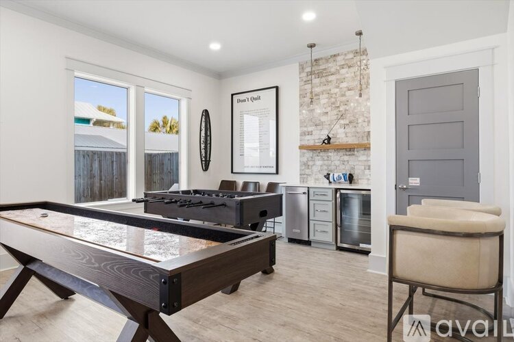A modern kitchen with a pool table in the middle.