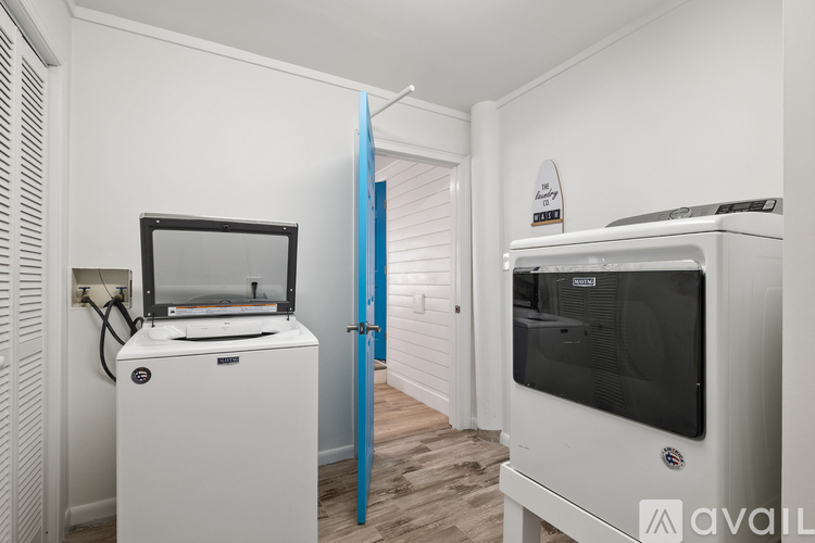A white fridge with a black top and a white microwave with a black top are in a kitchen.