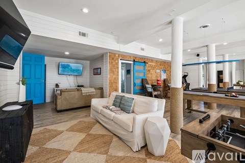 A living room with a white couch and a wooden floor.