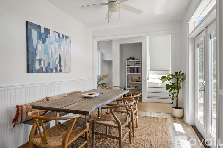 A dining room with a wooden table and chairs.
