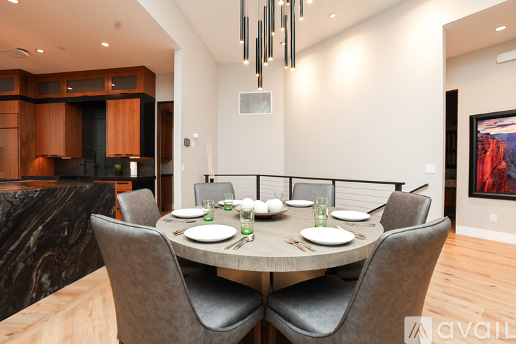 A modern dining room with a round table set for six.