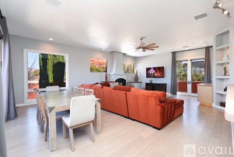 A living room with a red couch and a glass table.