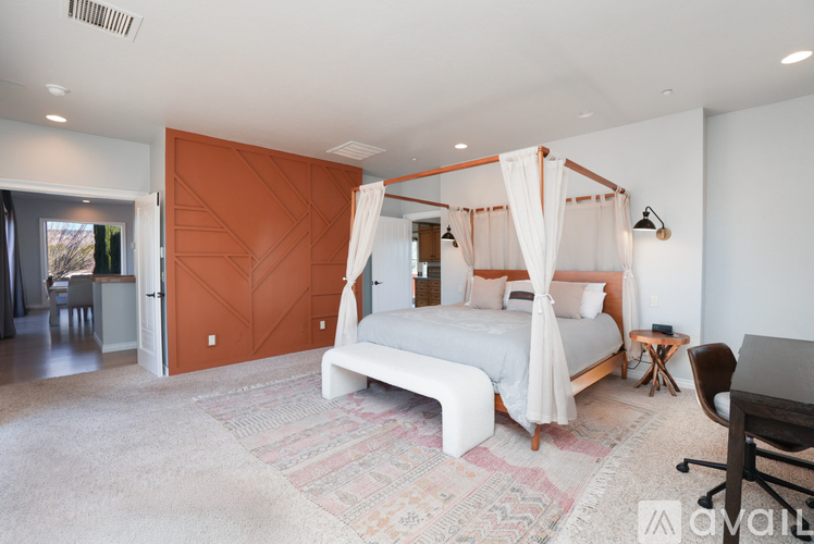 A bedroom with a canopy bed and a bench.