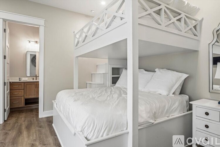 A white bedroom with a bunk bed and a dresser.