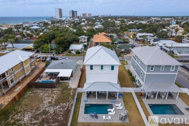 A house with a pool in the foreground and a city skyline in the background.