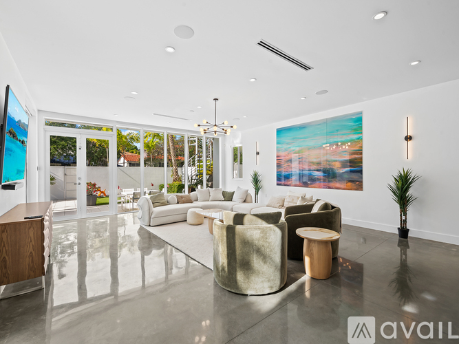 A modern living room with a large sofa set and a painting on the wall.