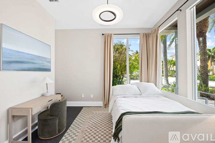 A bedroom with a large bed and a desk with a lamp.