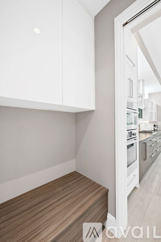A kitchen with white cabinets and a wooden floor.