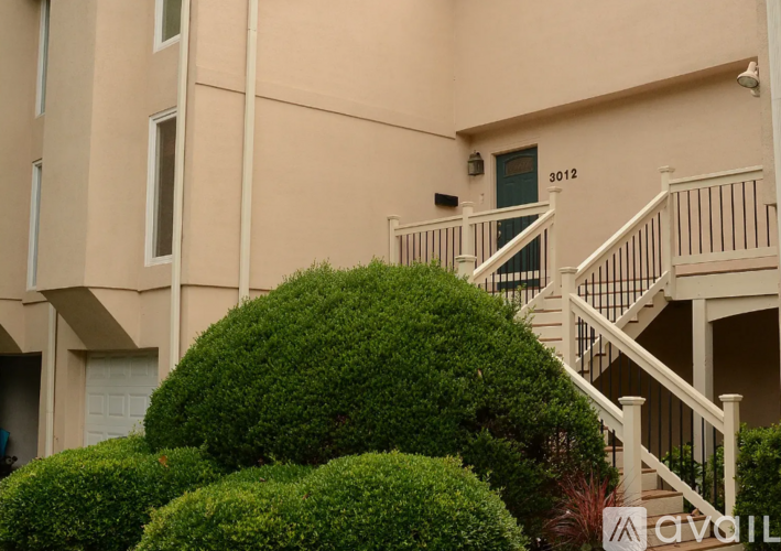 A building with a green door and a staircase leading to the entrance.