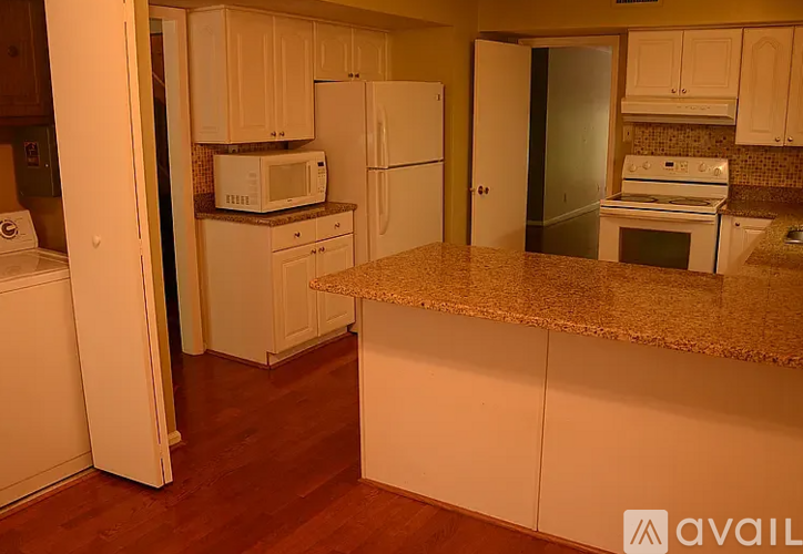 A kitchen with white appliances and cabinets.