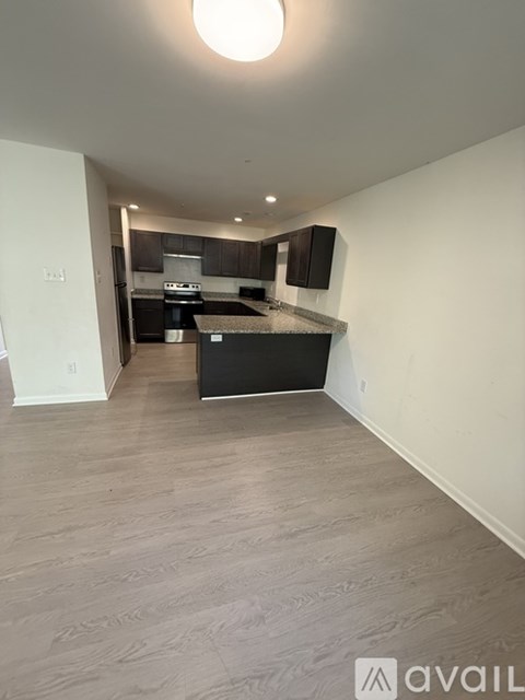 A kitchen area with a black countertop and cabinets.