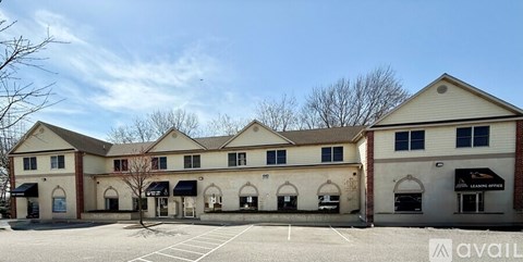 A large commercial building with a parking lot in front.