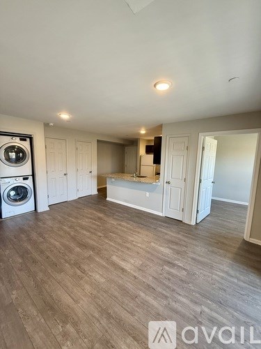 A room with wooden flooring and a washing machine in it.