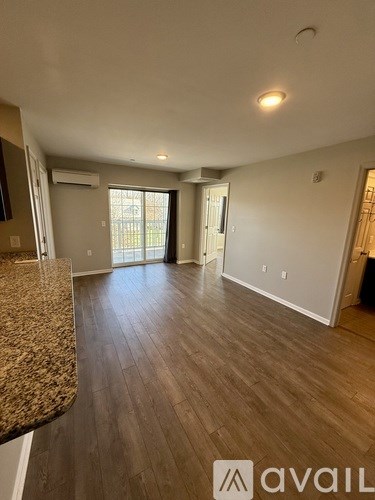 A spacious room with a granite countertop and wooden flooring.