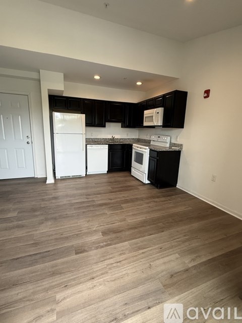 A kitchen with black cabinets and white appliances.