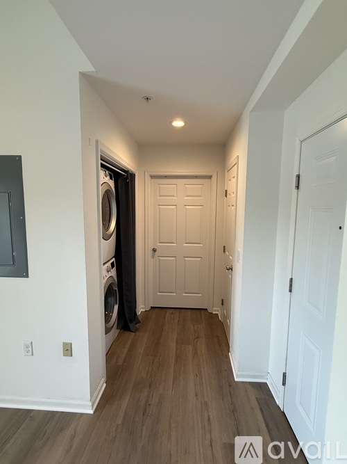 A hallway with a washer and dryer in the doorway.