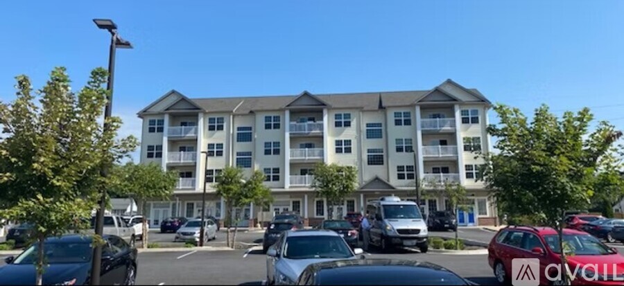 A large apartment building with a parking lot in front of it.