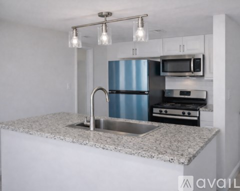 A kitchen with a granite countertop and stainless steel appliances.