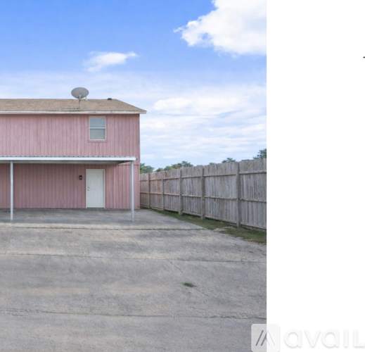 A pink building with a white door and a satellite dish on the roof.